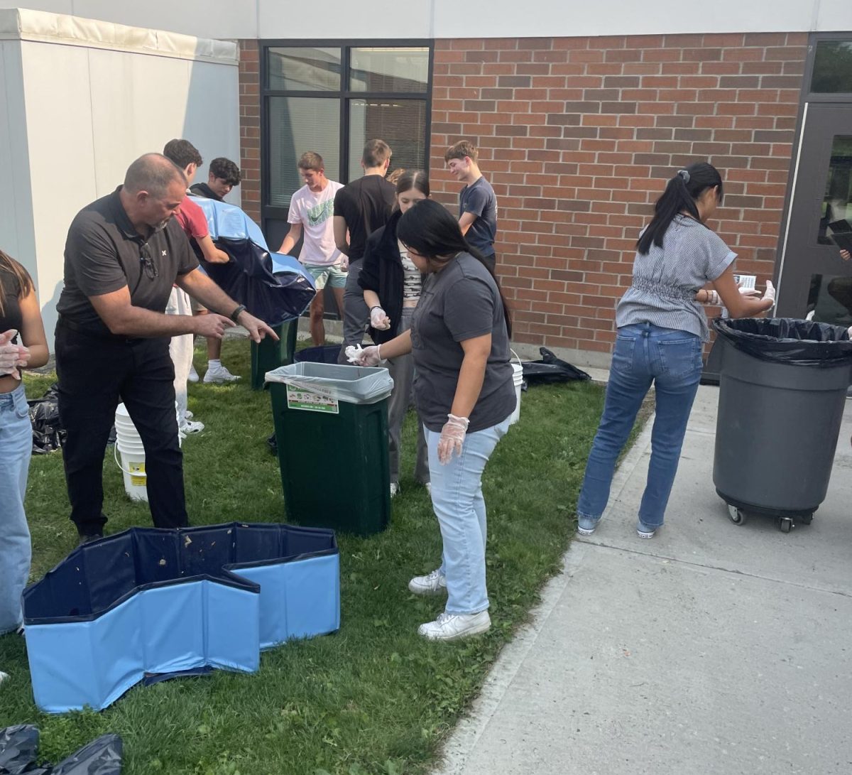 Students in AG 2 Leadership sort through garbage, separating into compostable, recyclable, and trash. 