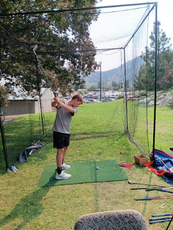 CHS student Albin Eskew swings a golf club on Sunday at the First Tee booth, which is new to the fair this year.