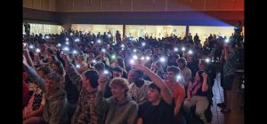 CHS Students raising their flashlights while Gracie Rengelli sings.