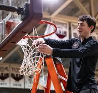 Coach Eygabroad cuts down the net after leading Rainer High School to its first district title since 2011