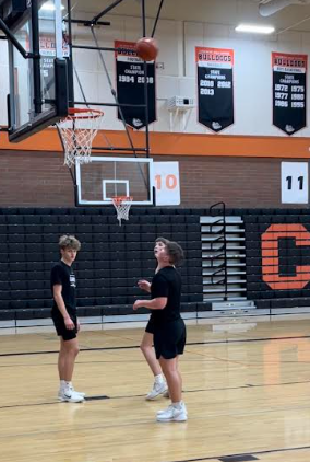 Sophomores Mac Carlson and Colton Bjorklund and freshman Grant Perkins watch as a buzzer beater shot sails through the air toward the hoop on Tuesday night’s practice. 
