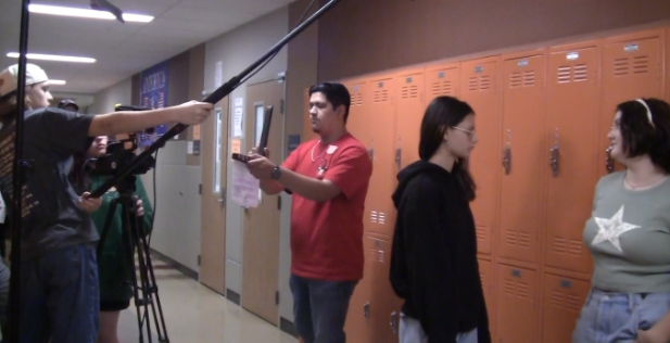 A clip from behind the scenes showing Meloy holding the microphone, Fernandez holding the clapper, and Graham and Hemmer getting in character for their big scene. 