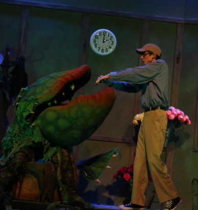 Scene capturing the unfortunate ritual Seymour (Kaid Devereaux) has to follow in order to keep his plant alive.