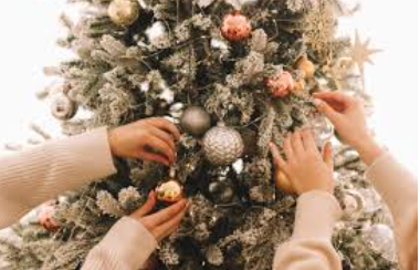 People decorating their Christmas tree.